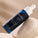This image showcases a bottle of Ocean Dive, a pore-clearing serum. The dark blue packaging, featuring a dropper applicator, highlights its key ingredients: blue algae glucosamine and salicylic acid. The product is certified organic and is designed to refine pores, clear skin, and promote a smooth complexion. It is elegantly displayed on a natural stone surface, emphasising its eco-conscious and natural formulation.